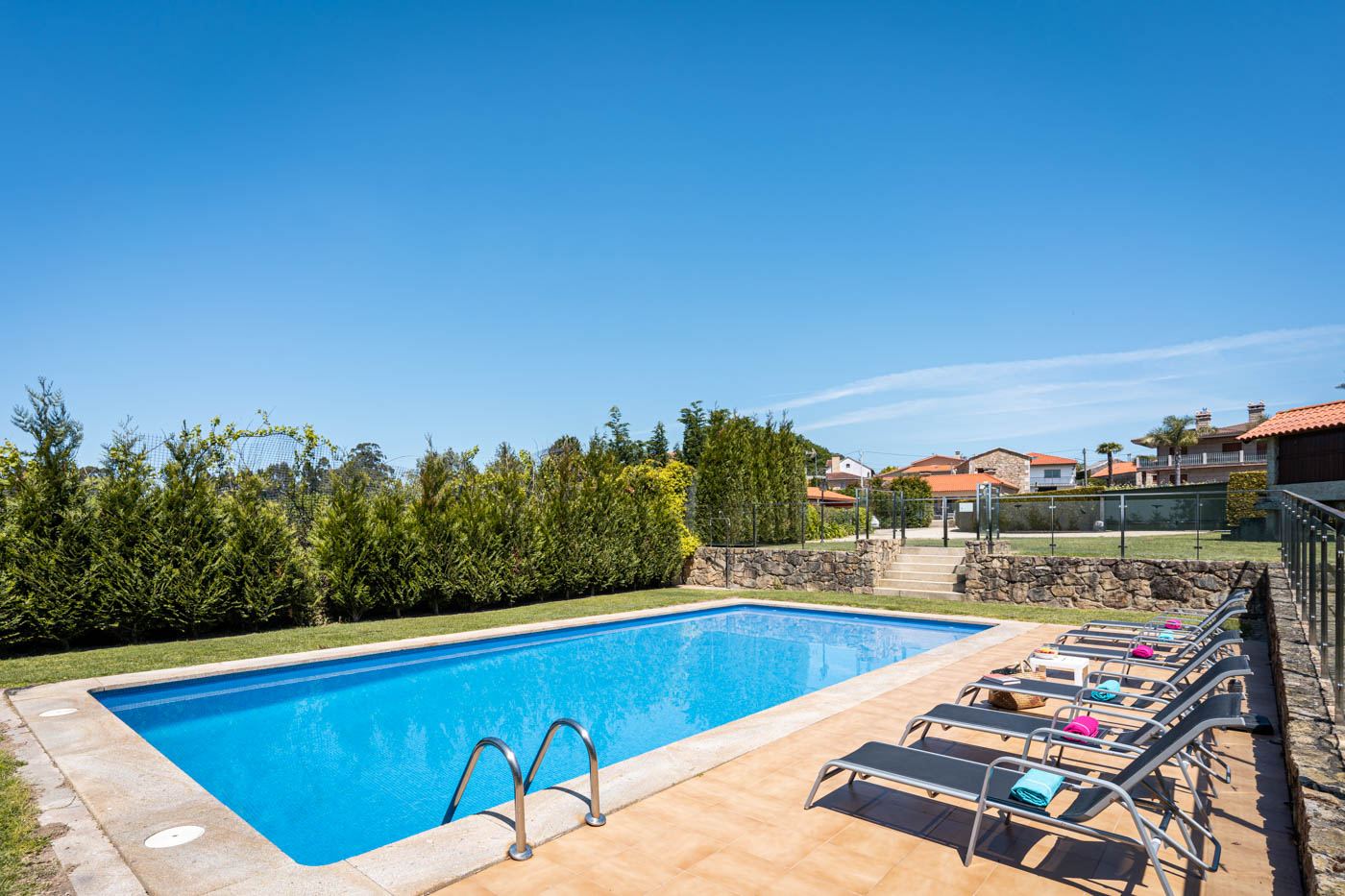 Piscina privada con tumbonas