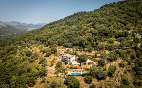 Tu casa rural vista desde la distancia, con las montañas de Ronda al fondo