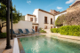 Pool area next to furnished patio with barbecue