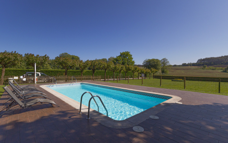 Fenced pool is next to parking area